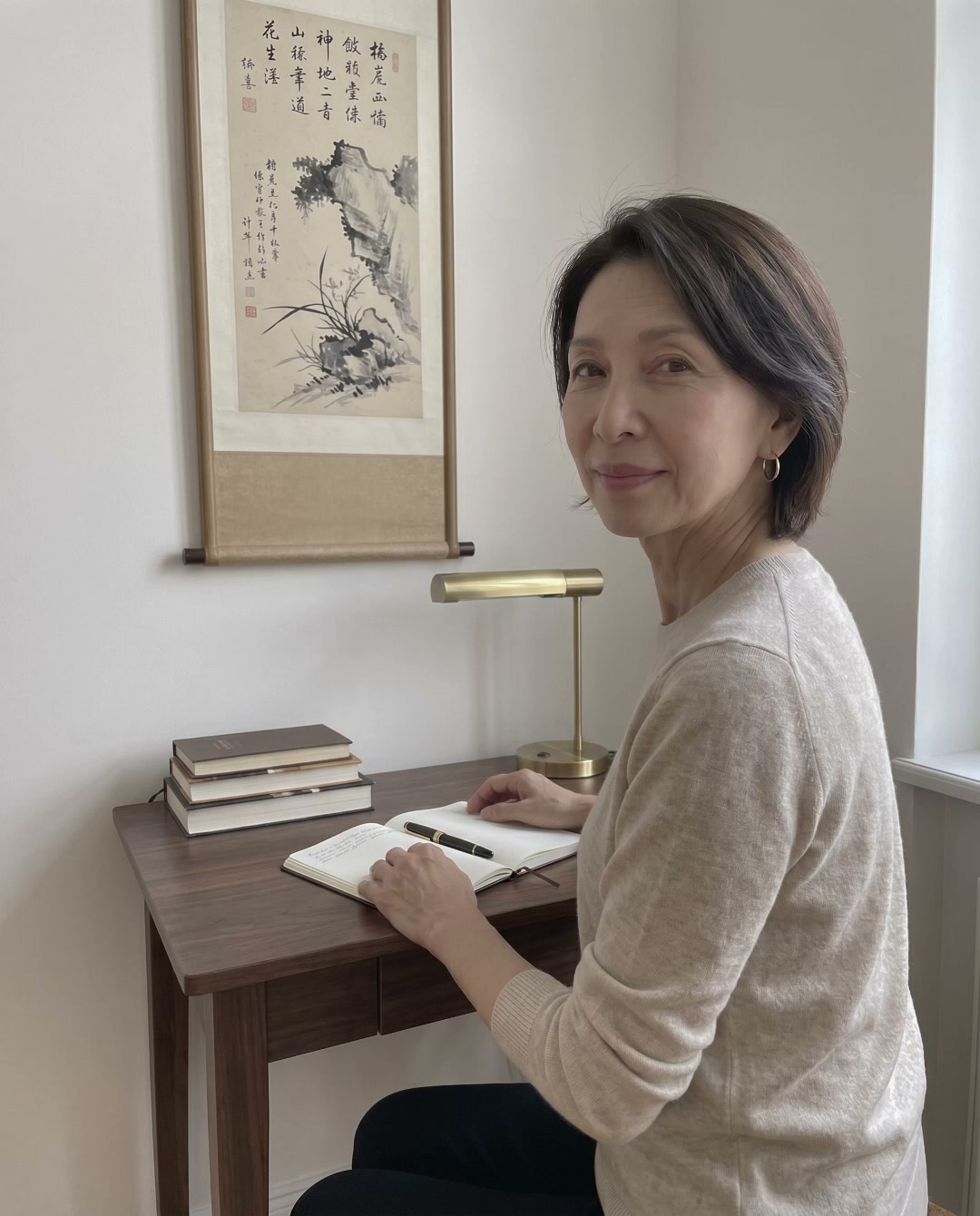 Hae-won Park przy biurku w swoim krakowskim gabinecie, w owsianym swetrze, z otwartym notatnikiem — fotografia z 2026 roku.